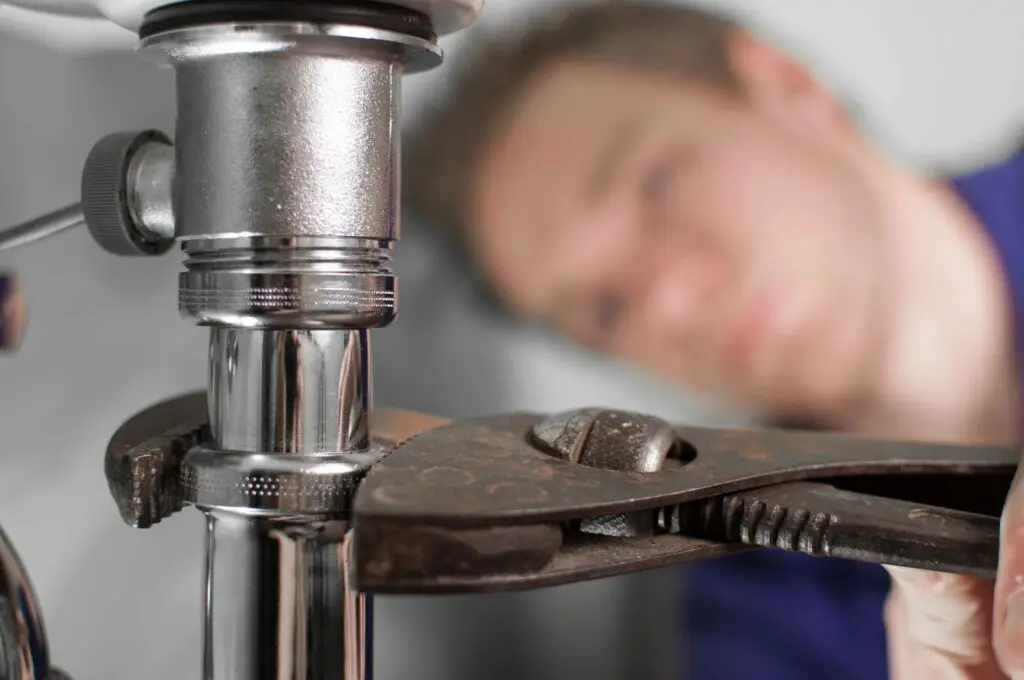 Plumber working under a kitchen sink